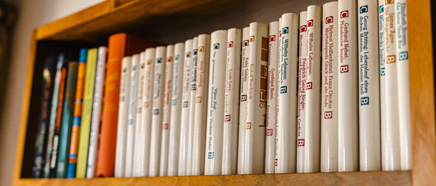 Ein Holzregal mit einer Reihe von Büchern in weißen Einbänden, ordentlich nebeneinander aufgereiht., © SMG Stuttgart Marketing GmbH - Sarah Schmid Ein Holzregal mit einer Reihe von Büchern in weißen Einbänden, ordentlich nebeneinander aufgereiht., © SMG Stuttgart Marketing GmbH - Sarah Schmid