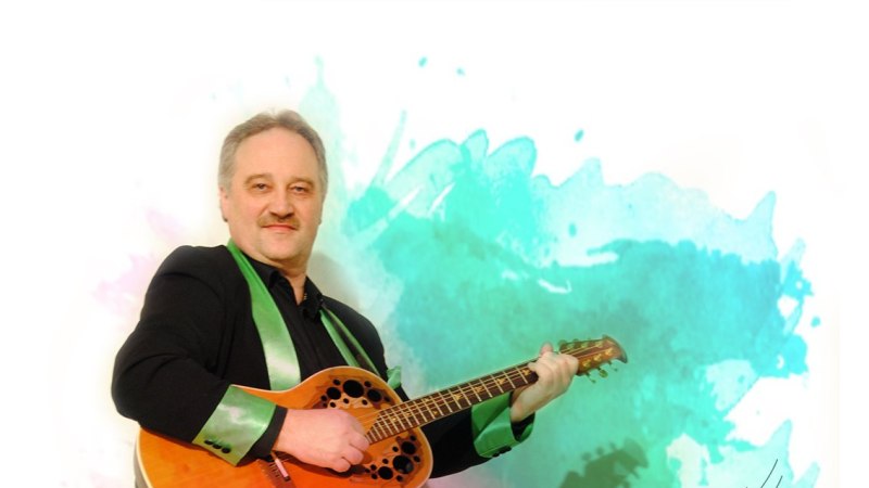 Ein Mann spielt Gitarre vor einem bunten Aquarellhintergrund. Der Text 'Manne's Singstunde' ist darunter zu sehen.