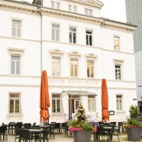 Historisches Geb&auml;ude mit wei&szlig;er Fassade, davor ein Caf&eacute; mit Tischen und Pflanzen. Die Architektur erinnert an die fr&uuml;here Weberei Gutmann., &copy; Stadt G&ouml;ppingen