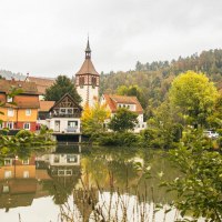 Stadtsee in Bad Liebenzell mit bunten Häusern und Kirchturm, umgeben von herbstlichen Bäumen. Spiegelung im Wasser, umrahmt von grünen Büschen., © SMG, Sarah Schmid Stadtsee in Bad Liebenzell mit bunten Häusern und Kirchturm, umgeben von herbstlichen Bäumen. Spiegelung im Wasser, umrahmt von grünen Büschen., © SMG, Sarah Schmid