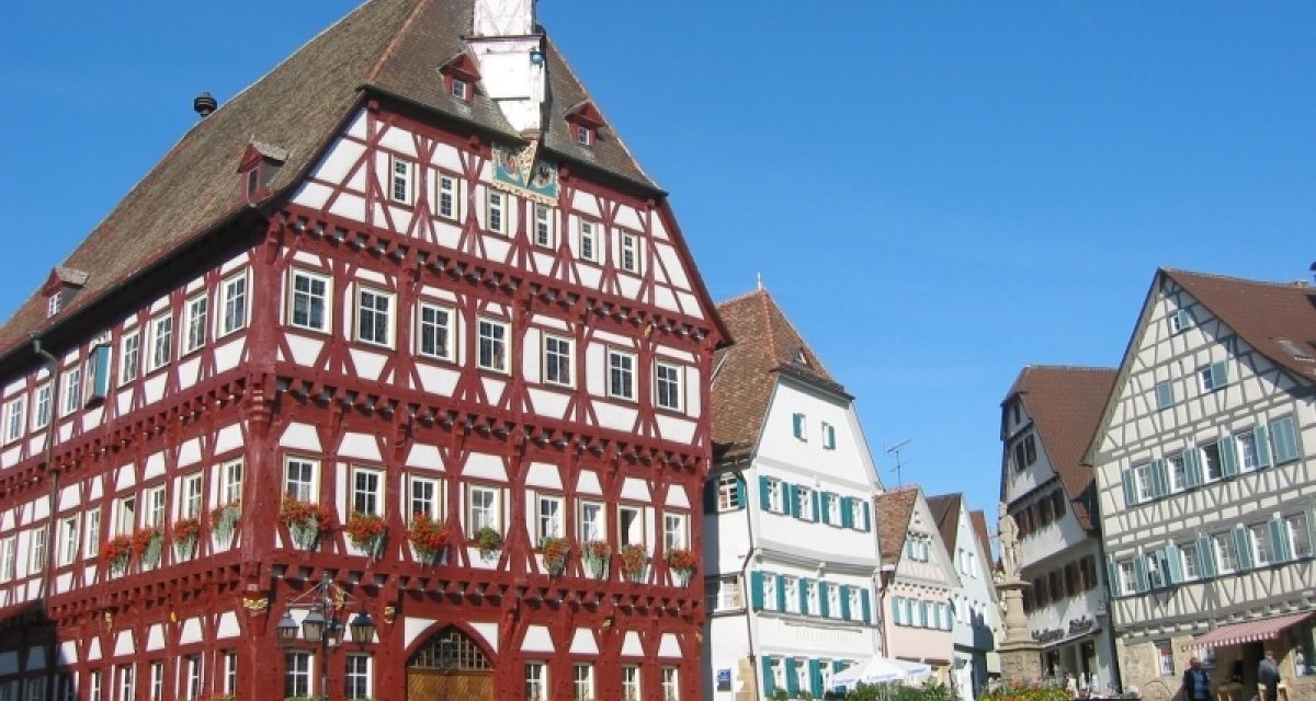 Fachwerkh&auml;user am Marktplatz in Markgr&ouml;ningen, darunter ein gro&szlig;es rotes Geb&auml;ude. Blauer Himmel und sonniges Wetter., &copy; Aktiv-Region Stuttgart
