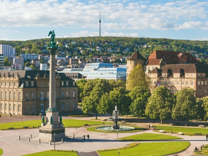 Der Schlossplatz in Stuttgart mit einer Säule und einem Brunnen im Vordergrund. Im Hintergrund ist der Fernsehturm zu sehen., © Schlienz-Tours GmbH & Co.KG Der Schlossplatz in Stuttgart mit einer Säule und einem Brunnen im Vordergrund. Im Hintergrund ist der Fernsehturm zu sehen., © Schlienz-Tours GmbH & Co.KG