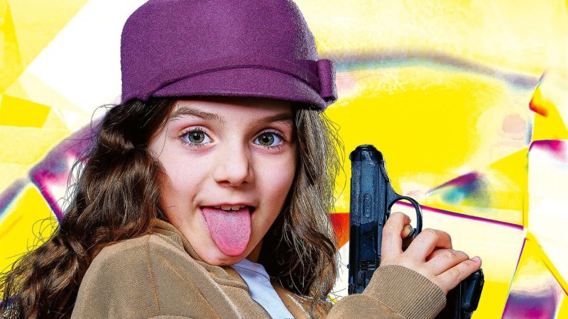 Mädchen mit lila Hut hält eine Spielzeugpistole und streckt die Zunge heraus. Der Hintergrund ist bunt und abstrakt gestaltet., © © Grafik: Christof Mühlberger  © Foto: Tobias Metz