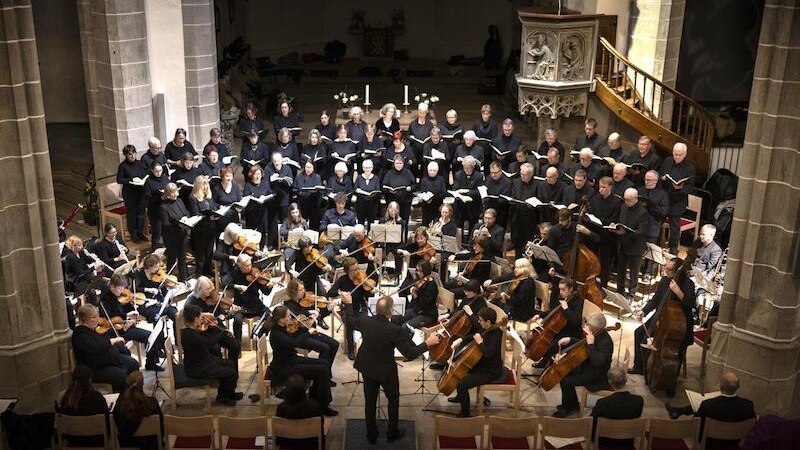 Ein Orchester und Chor führen in einer Kirche ein klassisches Konzert auf. Der Dirigent steht vor den Musikern, die in einem Halbkreis sitzen., © Evangelische Kirchengemeinde Waiblingen Ein Orchester und Chor führen in einer Kirche ein klassisches Konzert auf. Der Dirigent steht vor den Musikern, die in einem Halbkreis sitzen., © Evangelische Kirchengemeinde Waiblingen