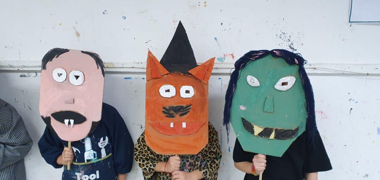 Drei Kinder präsentieren bunte, selbstgemachte Tiermasken aus Pappe. Die Masken sind fantasievoll gestaltet und zeigen verschiedene Tiergesichter., © Kunstschule Labyrinth Drei Kinder präsentieren bunte, selbstgemachte Tiermasken aus Pappe. Die Masken sind fantasievoll gestaltet und zeigen verschiedene Tiergesichter., © Kunstschule Labyrinth