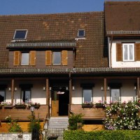 Ein traditionelles Gasthaus mit braunem Dach und Fensterläden. Der Balkon ist mit Blumen geschmückt. Der Schriftzug 'Hirsch' ist sichtbar., © Hotel Gasthof Hirsch
