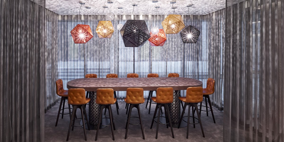 Moderner Konferenzraum mit ovalem Tisch, braunen Stühlen und geometrischen Hängelampen. Die Wände sind mit transparenten Vorhängen bedeckt., © Jaz Hotel Stuttgart