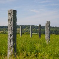 Mehrere Steinsäulen stehen in einer grünen Wiese, umgeben von Hügeln und Wald im Hintergrund unter einem blauen Himmel., © Remstal Tourismus e.V. Mehrere Steinsäulen stehen in einer grünen Wiese, umgeben von Hügeln und Wald im Hintergrund unter einem blauen Himmel., © Remstal Tourismus e.V.