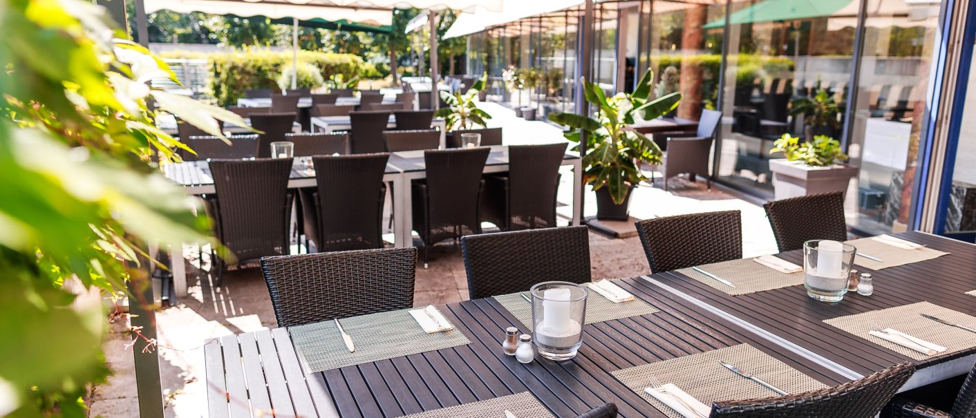 Restaurantterrasse mit gedeckten Tischen und Stühlen unter Markisen, umgeben von Pflanzen., © Plaza Residence Stuttgart-Ditzingen Restaurantterrasse mit gedeckten Tischen und Stühlen unter Markisen, umgeben von Pflanzen., © Plaza Residence Stuttgart-Ditzingen