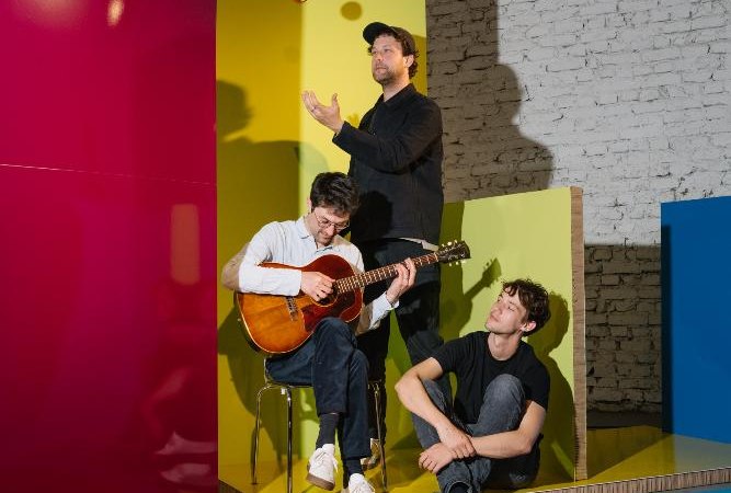 Drei M&auml;nner in einem Raum mit bunten W&auml;nden. Einer spielt Gitarre, ein anderer jongliert mit einem Apfel. Der dritte sitzt entspannt am Boden., &copy; EVENTSTIFTER GmbH