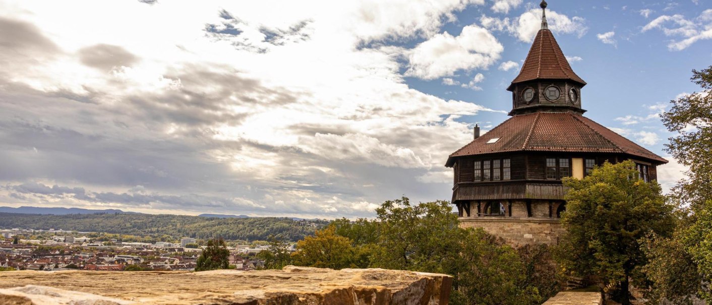 Der Dicker Turm in Esslingen erhebt sich über die Stadt, umgeben von Bäumen und unter einem dramatischen Himmel., © Stuttgart-Marketing GmbH, Sarah Schmid Der Dicker Turm in Esslingen erhebt sich über die Stadt, umgeben von Bäumen und unter einem dramatischen Himmel., © Stuttgart-Marketing GmbH, Sarah Schmid