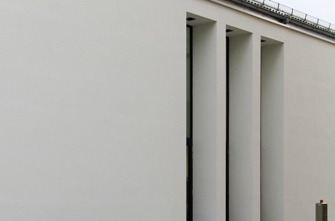 Weiße Gebäudefassade mit schmalen vertikalen Fenstern, die moderne Architektur betonen., © Kunsthalle Göppingen Weiße Gebäudefassade mit schmalen vertikalen Fenstern, die moderne Architektur betonen., © Kunsthalle Göppingen