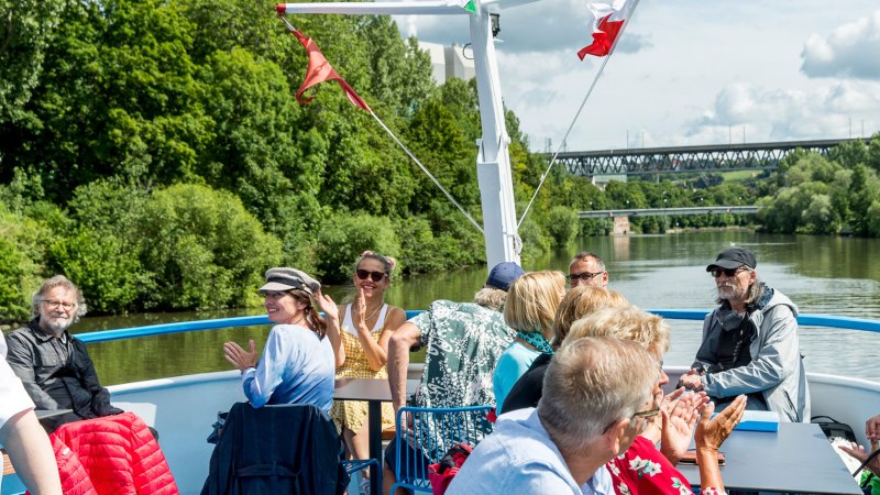 Menschen genießen eine Bootsfahrt auf dem Neckar. Sie sitzen auf dem Deck, umgeben von grüner Landschaft und unterhalten sich fröhlich., © all copyrights are reserved by maks richter Menschen genießen eine Bootsfahrt auf dem Neckar. Sie sitzen auf dem Deck, umgeben von grüner Landschaft und unterhalten sich fröhlich., © all copyrights are reserved by maks richter