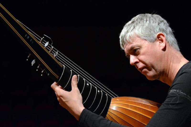 Ein Musiker spielt konzentriert auf einer Laute. Die Szene ist in warmem Licht gehalten, was eine intime Konzertatmosphäre schafft., © Jazzclub Schwäbisch Hall e.V. Ein Musiker spielt konzentriert auf einer Laute. Die Szene ist in warmem Licht gehalten, was eine intime Konzertatmosphäre schafft., © Jazzclub Schwäbisch Hall e.V.