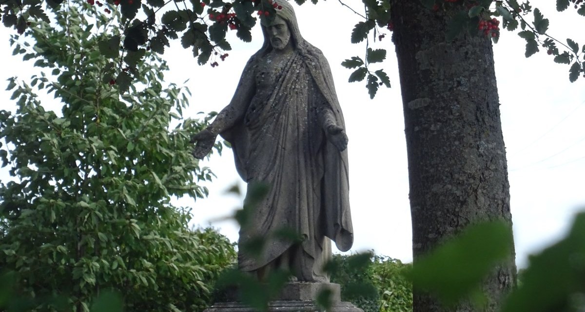 Eine Statue auf dem Friedhof Oberböbingen, umgeben von Bäumen und Blättern. Die Statue zeigt eine stehende Figur in einem Gewand., © Foto: Cornelia Steinbach Eine Statue auf dem Friedhof Oberböbingen, umgeben von Bäumen und Blättern. Die Statue zeigt eine stehende Figur in einem Gewand., © Foto: Cornelia Steinbach