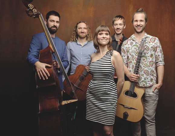 Eine f&uuml;nfk&ouml;pfige Musikgruppe posiert vor einem braunen Hintergrund. Die Mitglieder halten Instrumente und l&auml;cheln in die Kamera., &copy; Kulturstiftung Hohenlohe