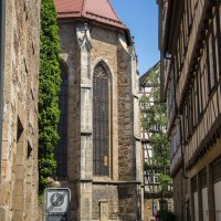 Gotische Martinskirche mit hohen Fenstern, umgeben von Fachwerkhäusern und einem Straßenschild im Vordergrund. Sonniger Tag, blauer Himmel., © Stadt Kirchheim unter Teck