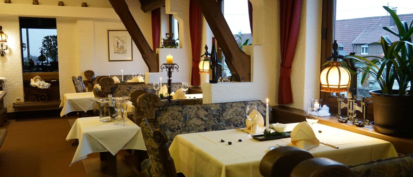 Ein gemütliches Restaurant mit Holzbalken, Kerzenlicht und elegant gedeckten Tischen. Die Einrichtung wirkt rustikal und einladend., © Hotel & Restaurant Beurener Hof Ein gemütliches Restaurant mit Holzbalken, Kerzenlicht und elegant gedeckten Tischen. Die Einrichtung wirkt rustikal und einladend., © Hotel & Restaurant Beurener Hof