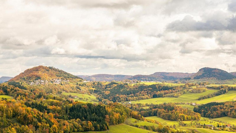 Herbstliche Landschaft mit bunten W&auml;ldern und H&uuml;geln um den Hohenstaufen bei G&ouml;ppingen. Wolkenverhangener Himmel und Windr&auml;der am Horizont., &copy; Stuttgart-Marketing GmbH, Sarah Schmid