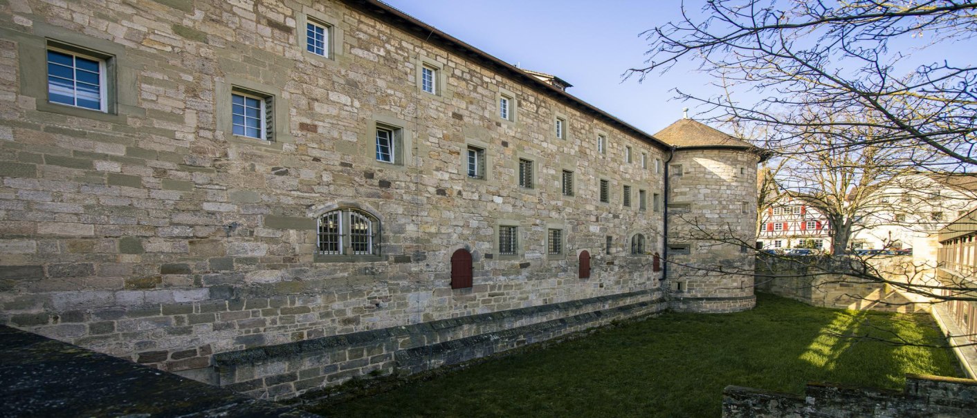 Seitenansicht des Schorndorfer Burgschlosses mit Steinmauer, Fenstern und einem Fachwerkhaus im Hintergrund., © SMG, Sarah Schmid Seitenansicht des Schorndorfer Burgschlosses mit Steinmauer, Fenstern und einem Fachwerkhaus im Hintergrund., © SMG, Sarah Schmid