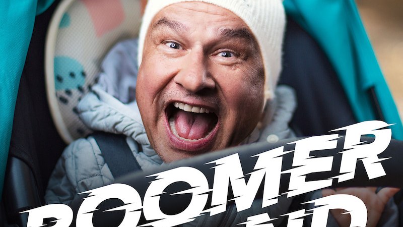 Ein fr&ouml;hlicher Mann mit wei&szlig;er M&uuml;tze l&auml;chelt in die Kamera. Der Schriftzug 'BOOMERLAND' ist prominent im Vordergrund platziert., &copy; Veranstaltungsring Metzingen e.V.