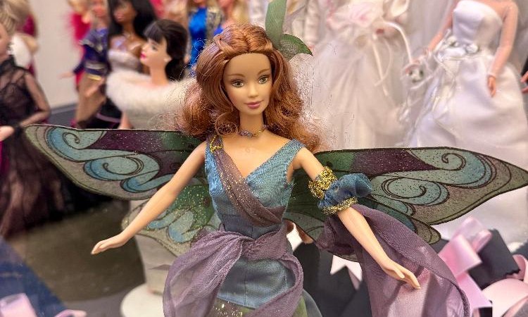 Eine Barbie-Puppe in einem Feenkostüm mit Flügeln steht im Vordergrund einer Ausstellung, umgeben von anderen Puppen in verschiedenen Outfits., © Staatliche Schlösser und Gärten Baden-Württemberg, Finia Saß Eine Barbie-Puppe in einem Feenkostüm mit Flügeln steht im Vordergrund einer Ausstellung, umgeben von anderen Puppen in verschiedenen Outfits., © Staatliche Schlösser und Gärten Baden-Württemberg, Finia Saß