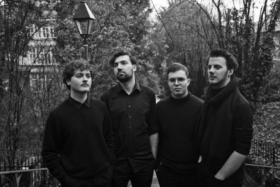 Vier Männer in schwarzer Kleidung stehen draußen vor einer Laterne, umgeben von kahlen Bäumen. Schwarz-Weiß-Fotografie., © Benjamin Friesinger/Lars Krech Quartett ©Christian Baur