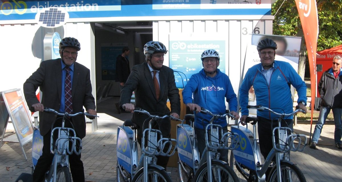 Vier Männer mit Helmen posieren vor einer E-Bike-Station in Holzgerlingen. Sie halten E-Bikes und lächeln in die Kamera., © Natur.Nah. Schönbuch & Heckengäu Vier Männer mit Helmen posieren vor einer E-Bike-Station in Holzgerlingen. Sie halten E-Bikes und lächeln in die Kamera., © Natur.Nah. Schönbuch & Heckengäu