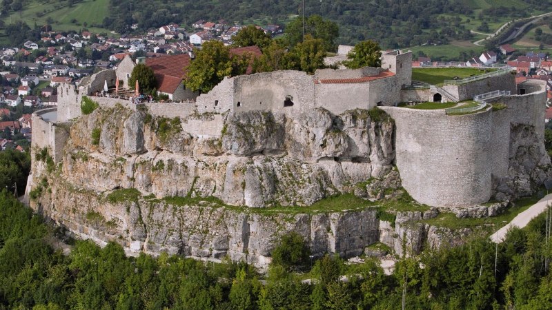 Die Ruine Hohenneuffen thront auf einem Hügel, umgeben von grüner Landschaft und einer Siedlung im Hintergrund., © Stuttgart-Marketing GmbH