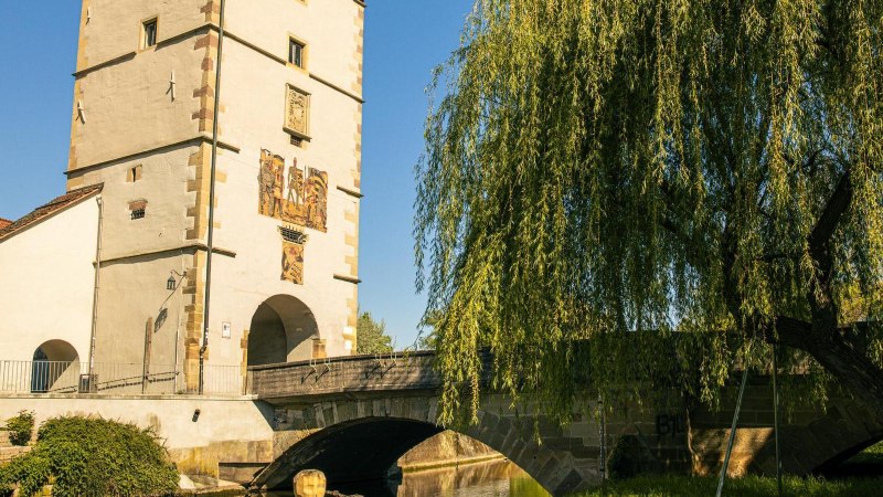 Das Beinsteiner Tor in Waiblingen, flankiert von einer Br&uuml;cke und einem gro&szlig;en Baum, bei strahlend blauem Himmel., &copy; Stuttgart-Marketing GmbH, Sarah Schmid