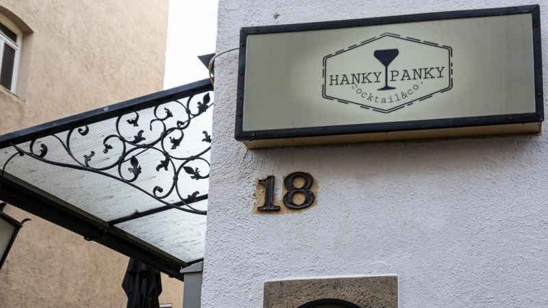 Ein Schild mit der Aufschrift 'Hanky Panky Cocktail & co' h&auml;ngt an einer Hauswand neben der Hausnummer 18. Eine Laterne und ein dekoratives Vordach sind sichtbar., &copy; Stuttgart-Marketing GmbH, Sarah Schmid