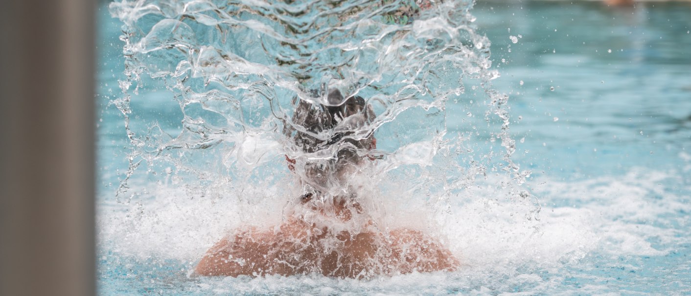 Eine Person steht in einem Pool unter einem Wasserfall, das Wasser spritzt in alle Richtungen. Die Szene wirkt erfrischend und entspannend., © Christophsbad Klinikgruppe Eine Person steht in einem Pool unter einem Wasserfall, das Wasser spritzt in alle Richtungen. Die Szene wirkt erfrischend und entspannend., © Christophsbad Klinikgruppe