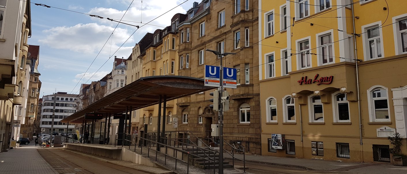 Straßenbahnhaltestelle in einer städtischen Straße, umgeben von alten Gebäuden. Ein Restaurant namens Ha Long ist zu sehen., © SMG