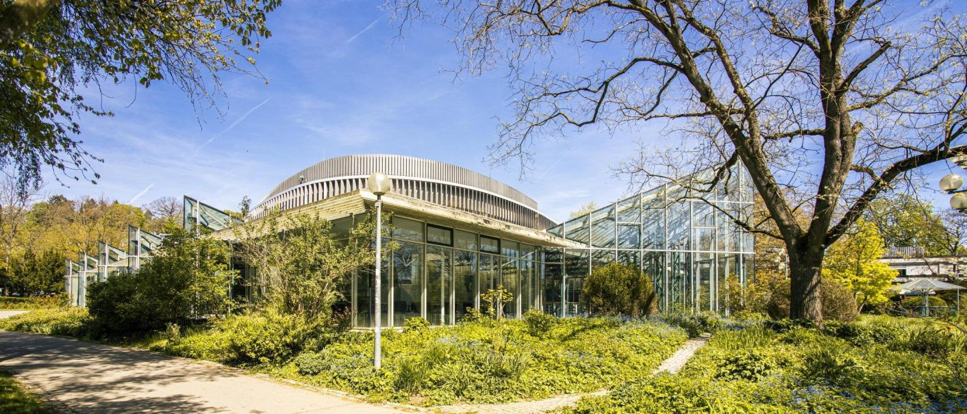Die Stadthalle Sindelfingen mit moderner Glasarchitektur und umgebendem Garten bei sonnigem Wetter., &copy; SMG, Sarah Schmid