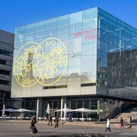 Das Kunstmuseum Stuttgart mit seinem markanten Glaskubus am Schlossplatz. Eine bunte Skulptur steht im Vordergrund, umgeben von modernen Gebäuden., © Stuttgart-Marketing GmbH, Sarah Schmid