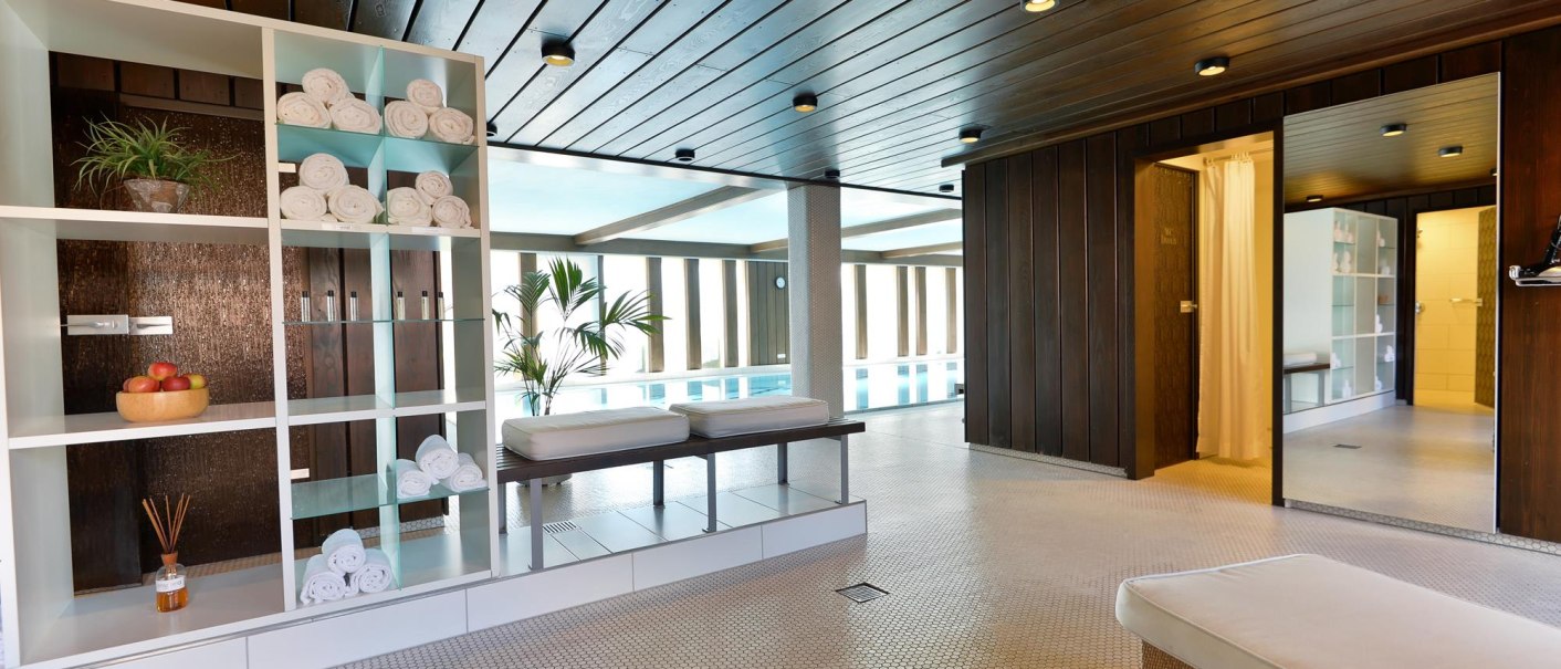 Moderner Wellnessbereich mit Pool, Liegen, Handtuchregalen und Pflanzen. Holzdecke und helle Fliesen schaffen eine entspannte Atmosphäre., © Ringhotel Adler Asperg