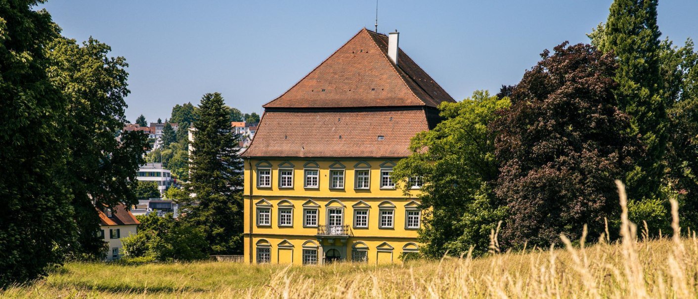 Das gelbe Schloss in Wernau steht majest&auml;tisch zwischen gr&uuml;nen B&auml;umen und einer Wiese unter klarem Himmel., &copy; Stuttgart-Marketing GmbH, Sarah Schmid