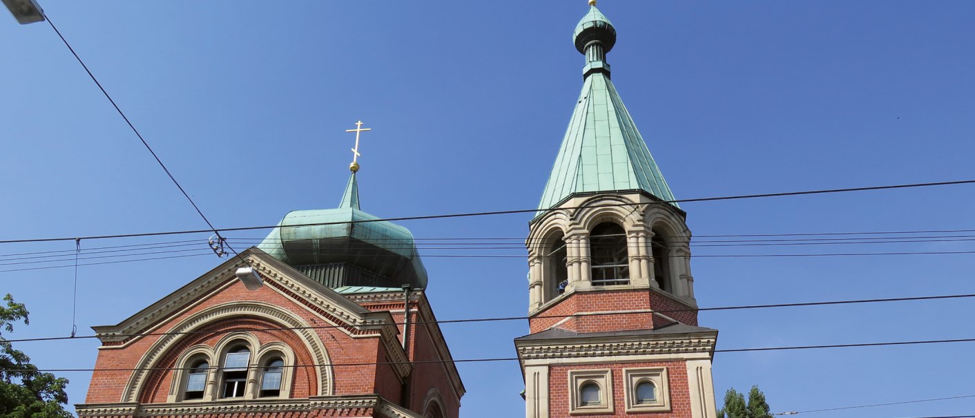 Zwei Kirchtürme der russischen Kirche St. Nikolai mit blauen Dächern und goldenen Kreuzen vor klarem Himmel., © SMG