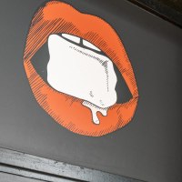 Illustration von roten Lippen mit einem Eisw&uuml;rfel auf schwarzem Hintergrund. Die Umgebung ist dunkel und industriell gestaltet., &copy; Stuttgart Marketing GmbH, Sarah Schmid