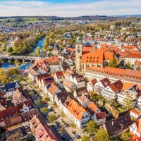 Luftaufnahme von Nürtingen im Frühling. Rote Dächer, eine Kirche und ein Fluss prägen das Stadtbild. Bäume blühen, die Landschaft ist grün., © Daniel Jüptner