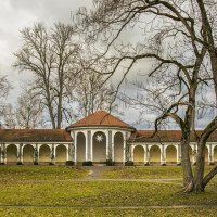 Historisches Kurhaus in Bad Boll mit Arkaden, umgeben von kahlen Bäumen und einem grünen Rasen im Vordergrund., © Stuttgart-Marketing GmbH, Sarah Schmid Historisches Kurhaus in Bad Boll mit Arkaden, umgeben von kahlen Bäumen und einem grünen Rasen im Vordergrund., © Stuttgart-Marketing GmbH, Sarah Schmid