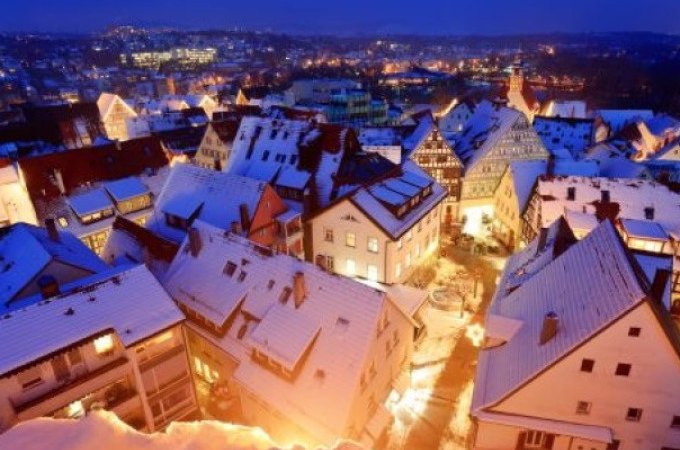 Verschneite Dächer einer Altstadt bei Nacht, beleuchtet von warmem Licht. Im Hintergrund sind Lichter der Stadt zu sehen., © WTM GmbH Waiblingen Verschneite Dächer einer Altstadt bei Nacht, beleuchtet von warmem Licht. Im Hintergrund sind Lichter der Stadt zu sehen., © WTM GmbH Waiblingen