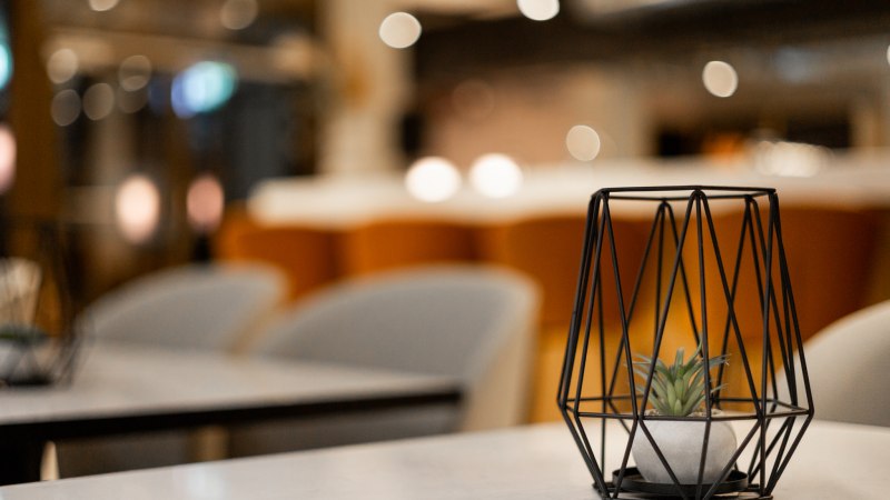 Geometrisches Tischdekor mit Pflanze in modernem Ambiente, unscharfer Hintergrund mit warmen Farben., &copy; GINN Apartments Esslingen