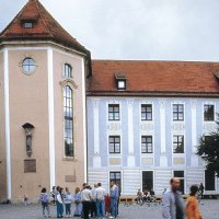 Historisches Gebäude mit Turm und roten Ziegeldach. Menschen stehen auf einem Platz davor. Der Himmel ist bewölkt., © Stuttgart-Marketing GmbH Historisches Gebäude mit Turm und roten Ziegeldach. Menschen stehen auf einem Platz davor. Der Himmel ist bewölkt., © Stuttgart-Marketing GmbH