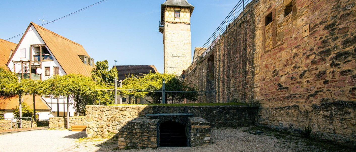 Blick auf eine historische Burgmauer und ein Fachwerkgebäude in Marbach am Neckar. Der Himmel ist klar und blau., © Stuttgart-Marketing GmbH, Sarah Schmid