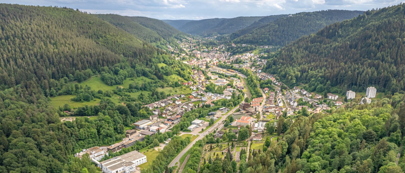Luftaufnahme von Bad Wildbad im Schwarzwald, eingebettet in ein enges, bewaldetes Tal mit Straßen, Häusern und grünen Hängen., © Lightworkart, Touristik Bad Wildbad GmbH Luftaufnahme von Bad Wildbad im Schwarzwald, eingebettet in ein enges, bewaldetes Tal mit Straßen, Häusern und grünen Hängen., © Lightworkart, Touristik Bad Wildbad GmbH