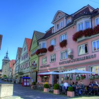Hotel Schillerhof in einer malerischen Altstadt mit Fachwerkh&auml;usern, einem Brunnen und Menschen, die im Freien sitzen. Sonniges Wetter und blauer Himmel., &copy; Hotel Schillerhof