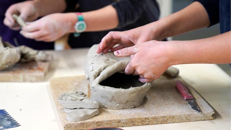 Zwei Personen formen Ton auf einem Tisch. Werkzeuge und Tonstücke sind sichtbar. Der Fokus liegt auf den Händen und dem Tonobjekt., © Kunstschule Labyrinth Zwei Personen formen Ton auf einem Tisch. Werkzeuge und Tonstücke sind sichtbar. Der Fokus liegt auf den Händen und dem Tonobjekt., © Kunstschule Labyrinth