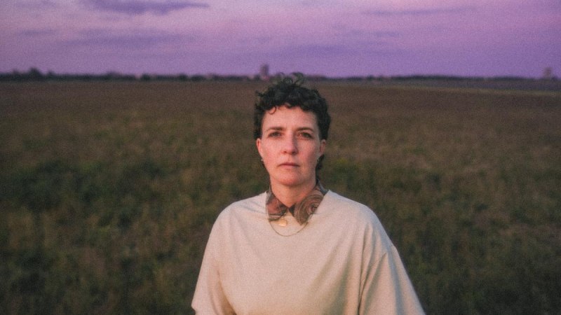 Eine Person steht auf einem Feld bei Sonnenuntergang. Der Himmel ist in lila und rosa T&ouml;nen gef&auml;rbt., &copy; Kulturzentrum Dieselstrasse