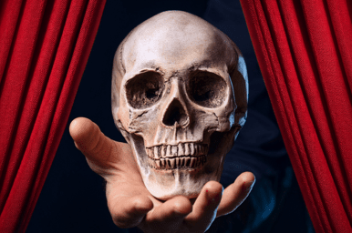 Eine Hand präsentiert einen Totenschädel zwischen roten Theatervorhängen, symbolisch für eine dramatische Szene., © Heute weder Hamlet Eine Hand präsentiert einen Totenschädel zwischen roten Theatervorhängen, symbolisch für eine dramatische Szene., © Heute weder Hamlet